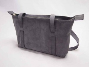 Camille in matgrijs, is een vrouwelijke schoudertas, elegant en modern door de getunnelde handvaten.