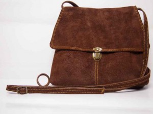 Sarah in bruine pilotenleer met gele stiksels.