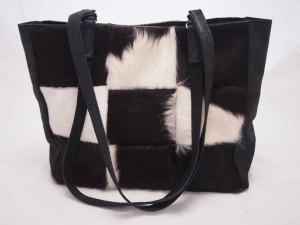 Edith is een patchwork shopper gemaakt van zwart/witte koeienhuid en zwart leer.