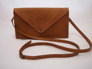 Lederen clutch 'Juliette' is uitgevoerd in bruin gevet leer en komt met een afneembare schouderband.